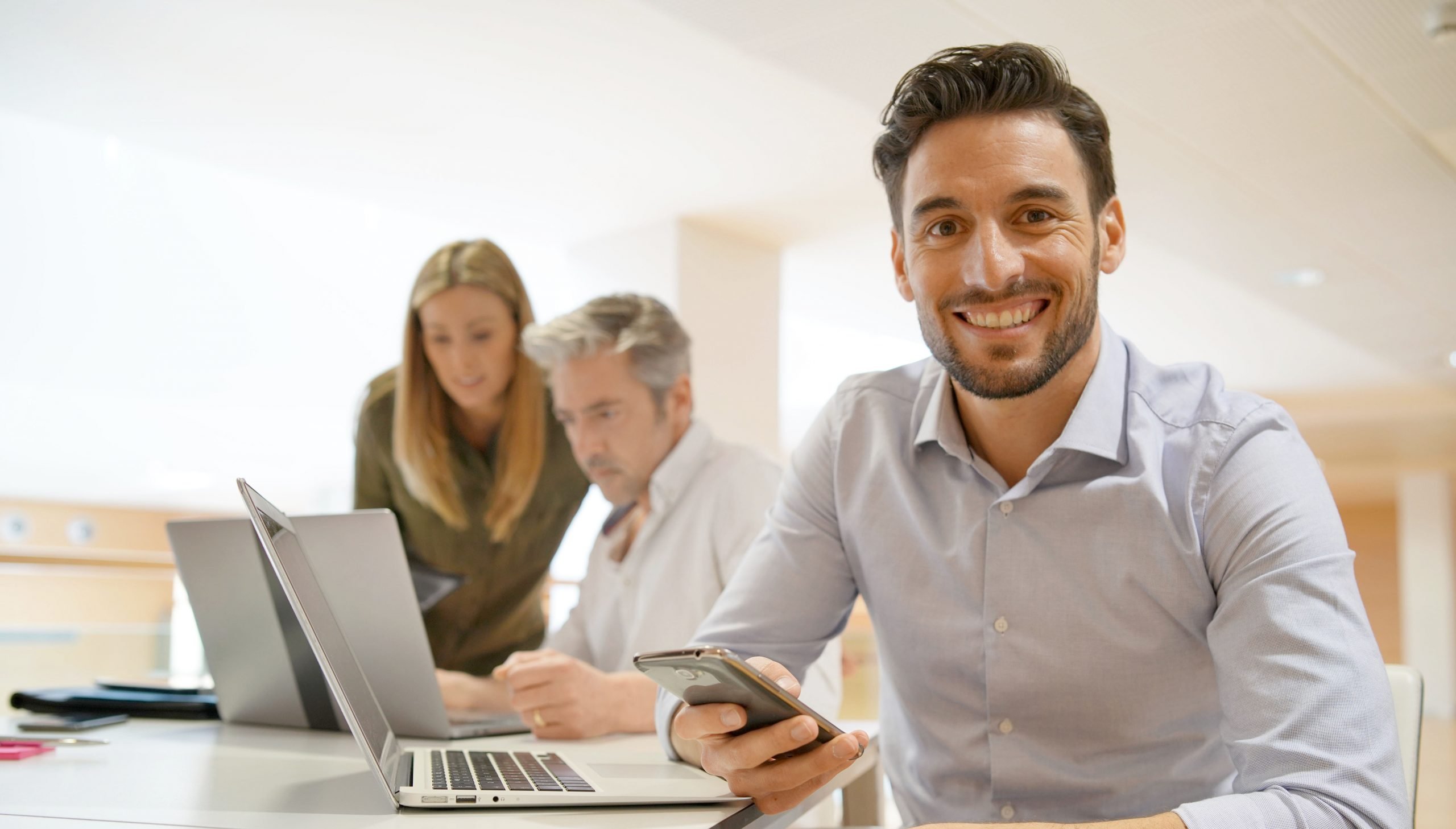 Startup team member smiling at camera in office