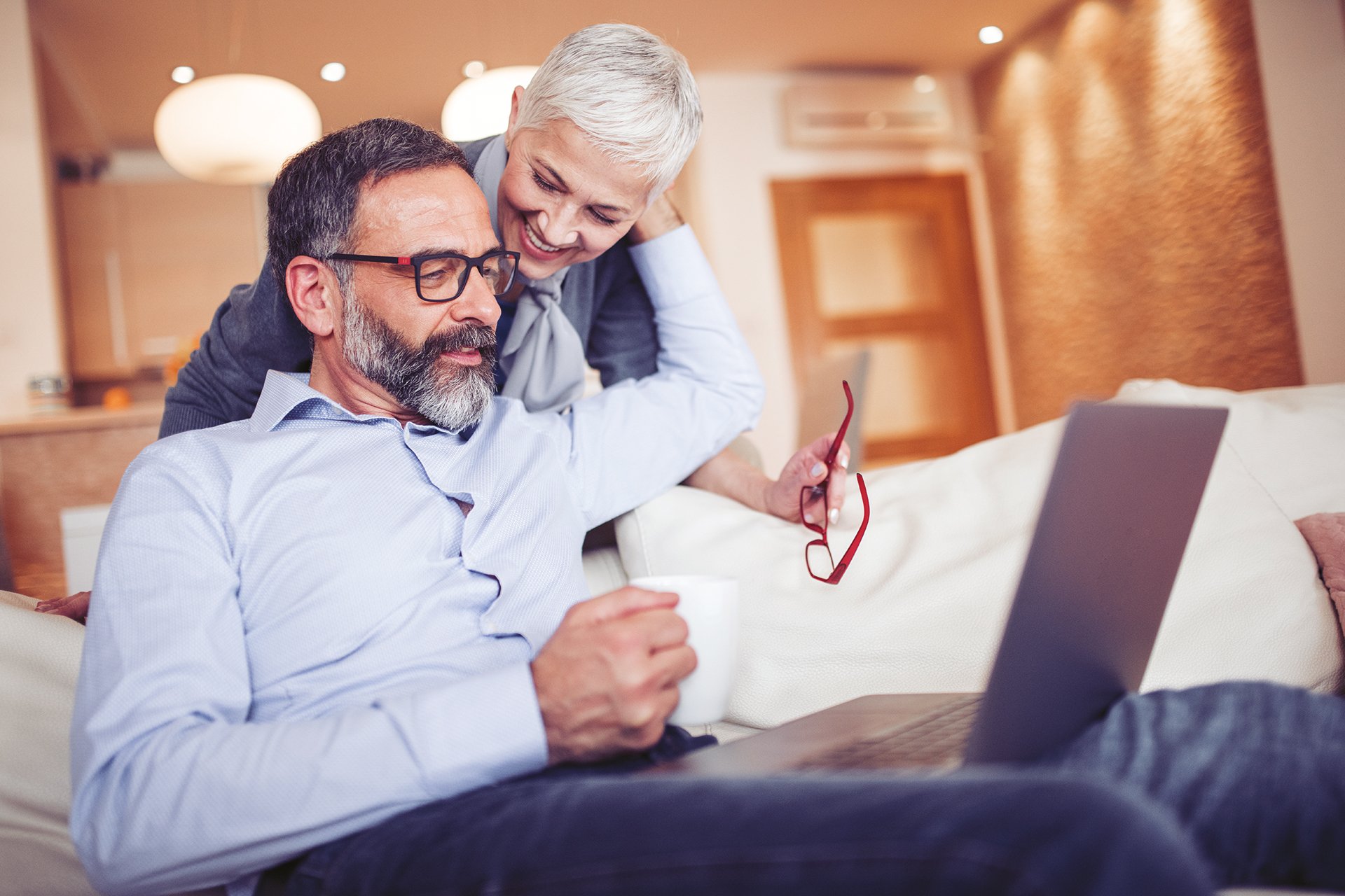 Mature couple using laptop computer at home
